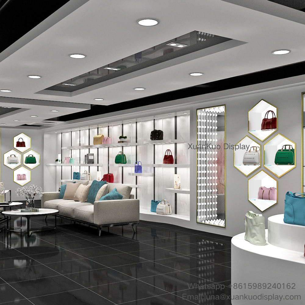 modern white gold handbag store display furniture full set, backlit multi-layer wall display shelves, independent hexagonal gold frame display niches, perforated light strip decorative panel, curved stepped handbag island, leisure consultation sofa area for ladies leather bag boutique